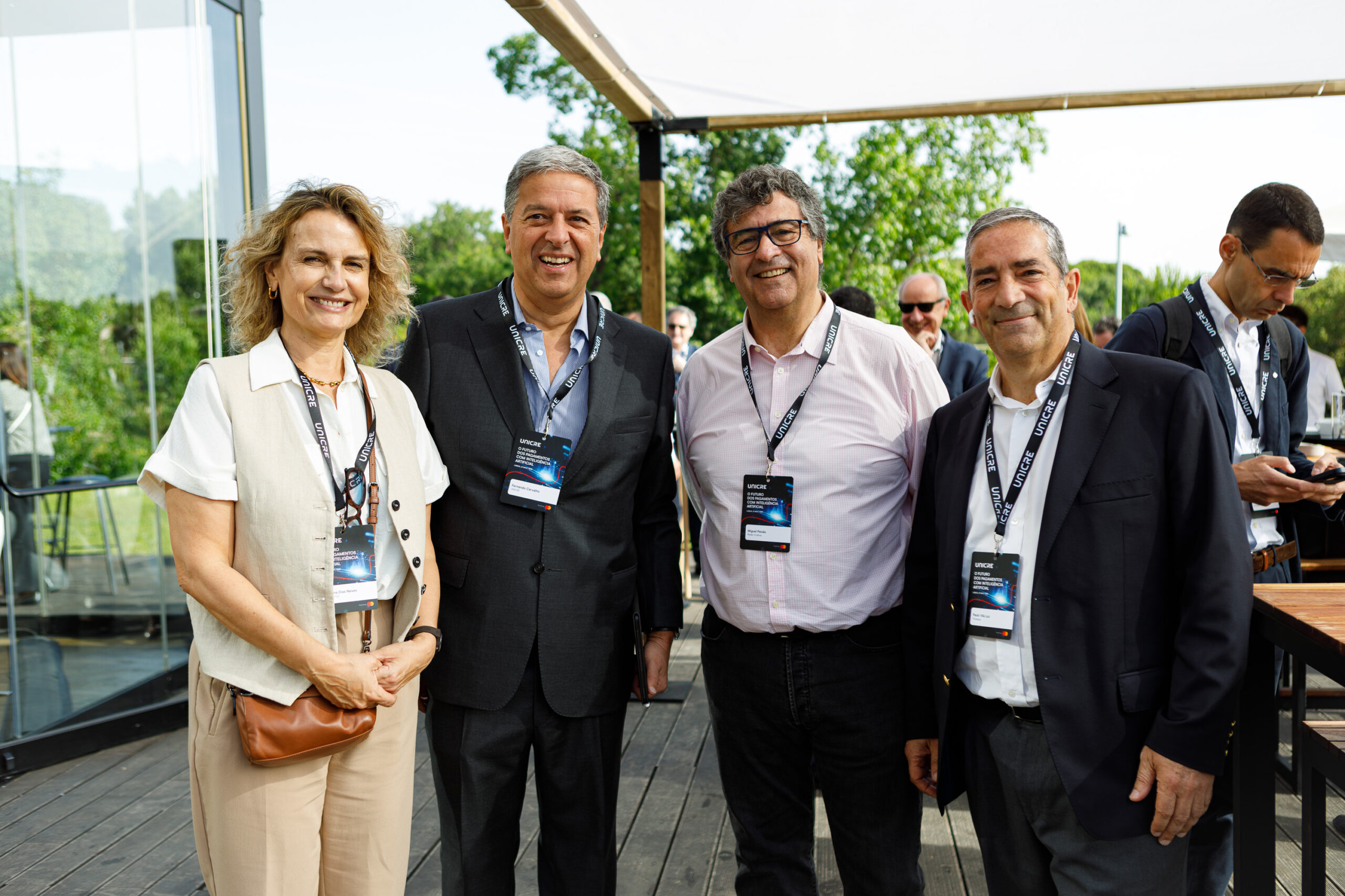 Five adults in business attire posing outdoors at a conference, smiling with UNICEF lanyards and badges visible.